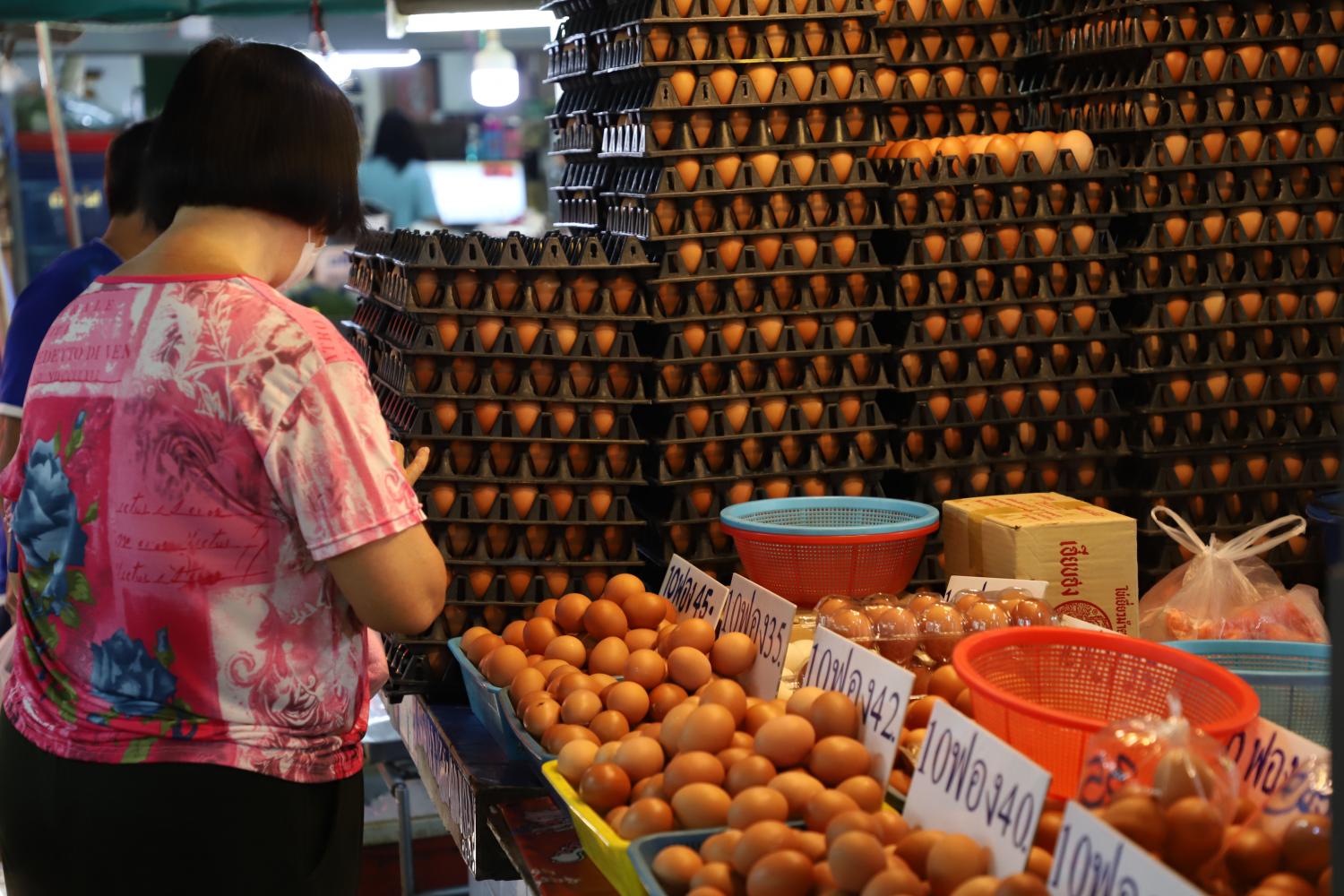 A woman shops at a market in Bangkok on March 15. A higher inflation rate in Thailand may cause domestic spending to recover slower than the EIC previously forecast. (Photo: Varuth Hirunyatheb)