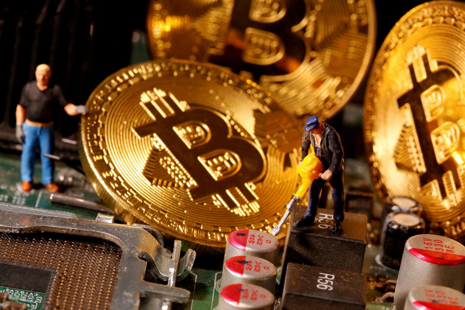 A representation of virtual currency Bitcoin and small toy figures are placed on computer motherboard in this illustration. (Reuters photo)