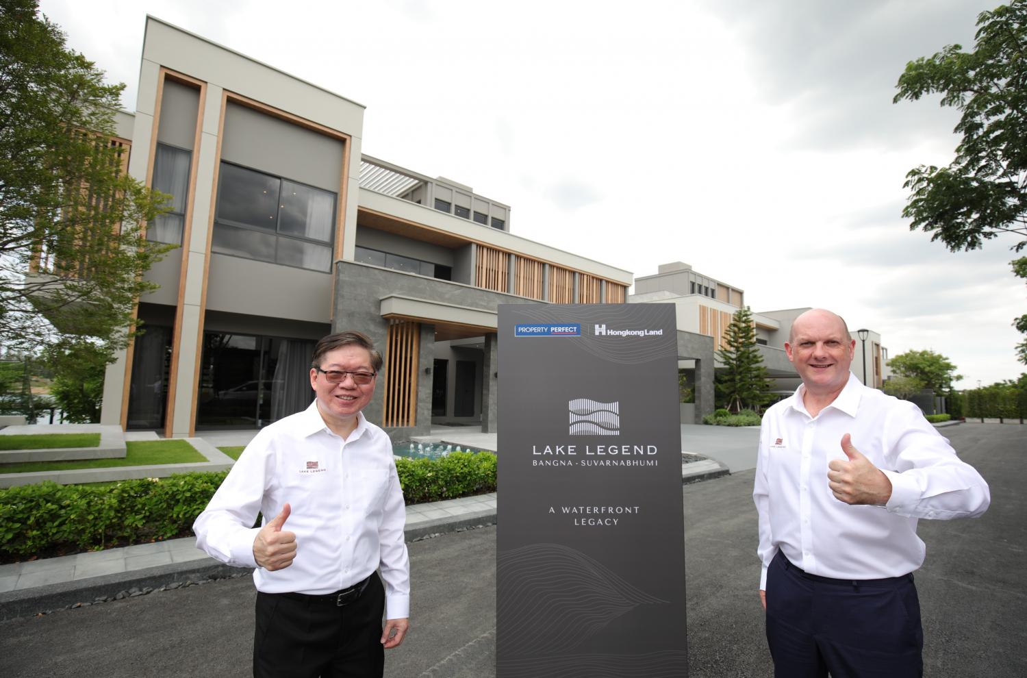 Mr Wongsakorn, left, and Mr Bright stand in front of lakeside sample houses priced at 120 million baht.