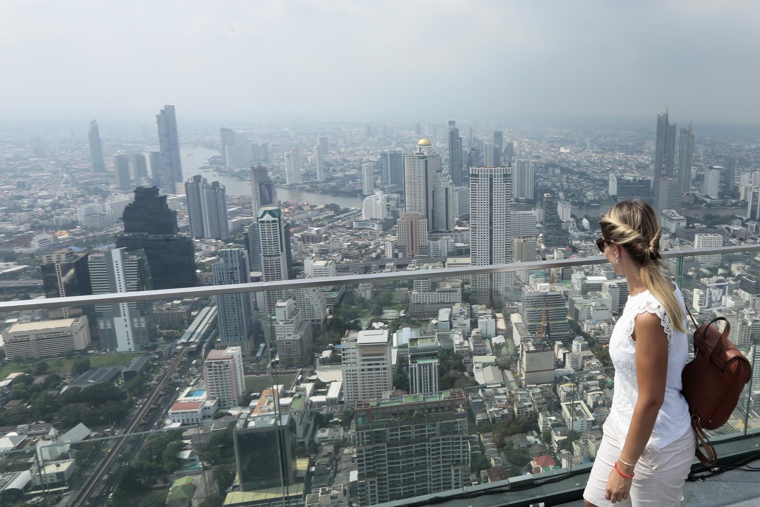 A tourist enjoys a spectacular view of Bangkok from the Mahanakhon Skywalk, one of the capital's tallest buildings. (Photo: Patipat Janthong)