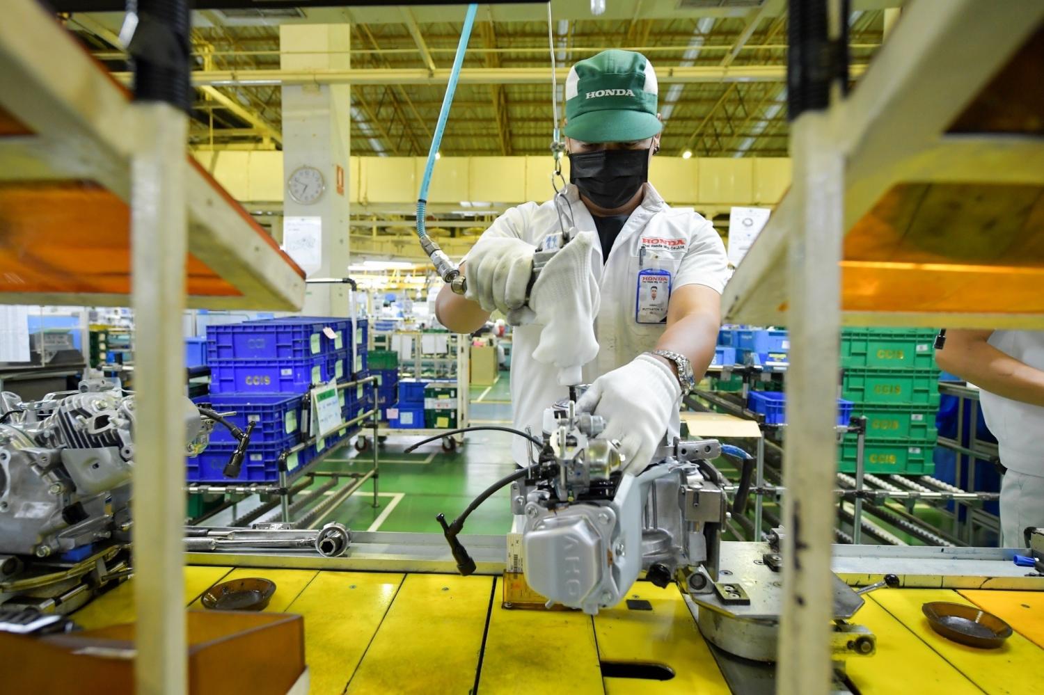 A worker utilises a tool on a production line at Thai Honda's factory in Lat Krabang, Bangkok.