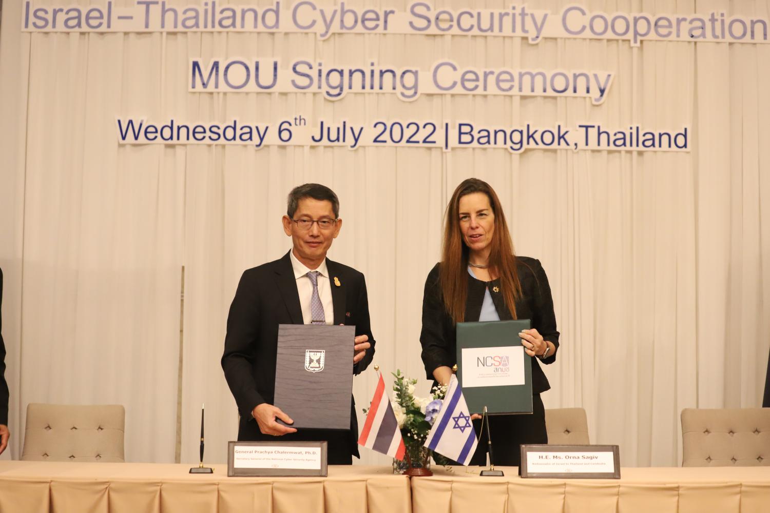 Gen Prachya Chalermwat, the NCSA secretary-general, left, and Orna Sagiv, Ambassador of Israel to Thailand, hold up their new MoU during a signing ceremony in Bangkok on Wednesday. (Photo: Pornprom Satrabhaya)