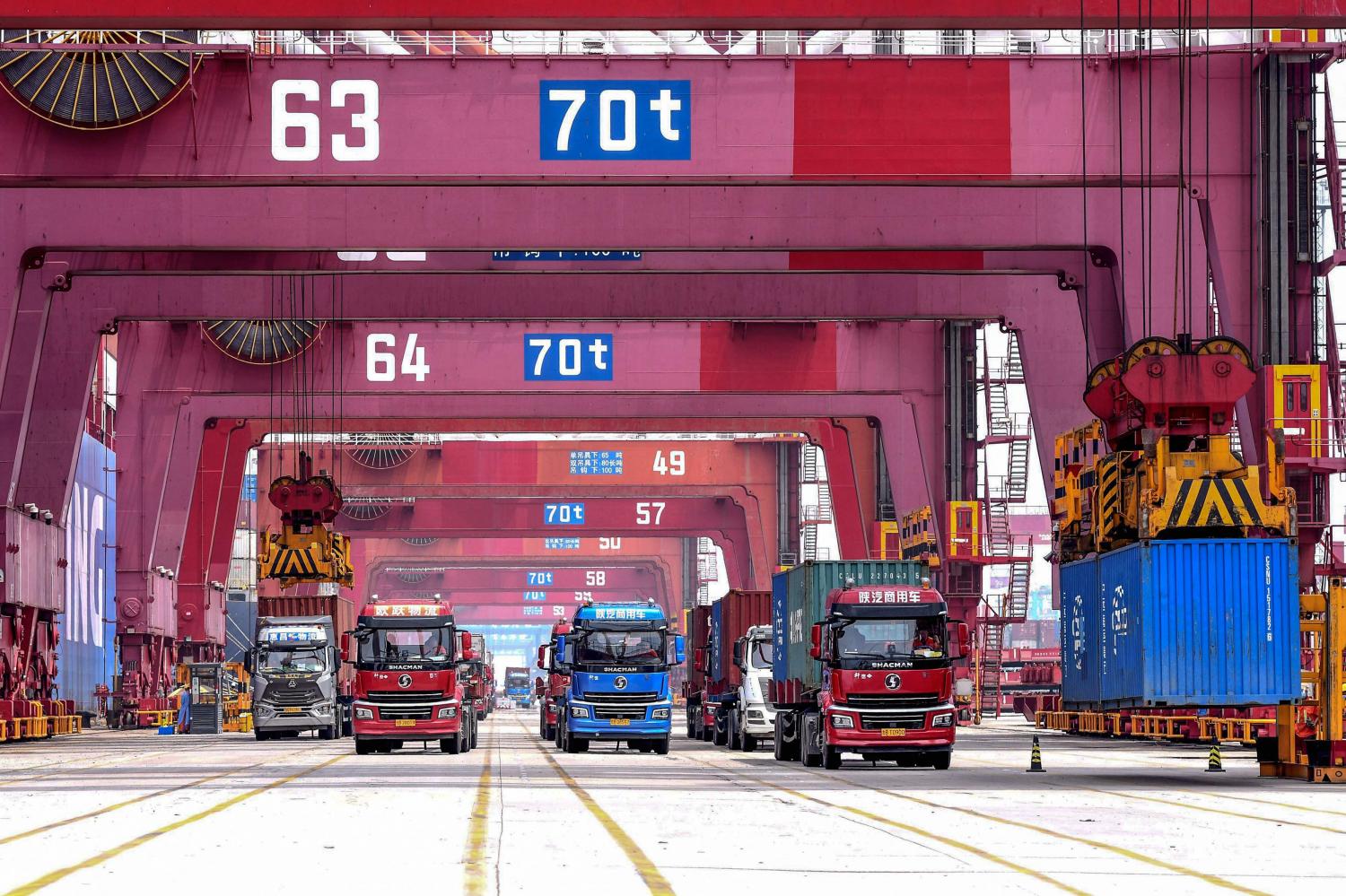 Cranes load containers onto trucks at a port in Qingdao, in China's eastern Shandong province on July 13, 2022. (AFP photo)