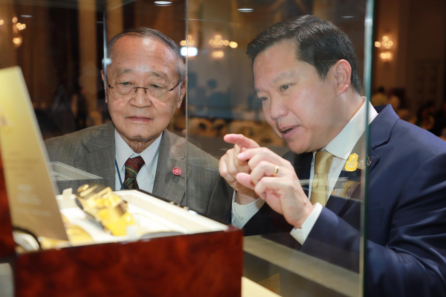 Thapana Sirivadhanabhakdi, CEO of ThaiBev, right, describes the unique design of the Royal Limited Edition Leica camera to Dr Sumet Tantivejkul, secretary-general of the Chaipattana Foundation, left, in Bangkok on Wednesday ahead of the auction of 22 of the cameras. (Photo: Somchai Poomlard)