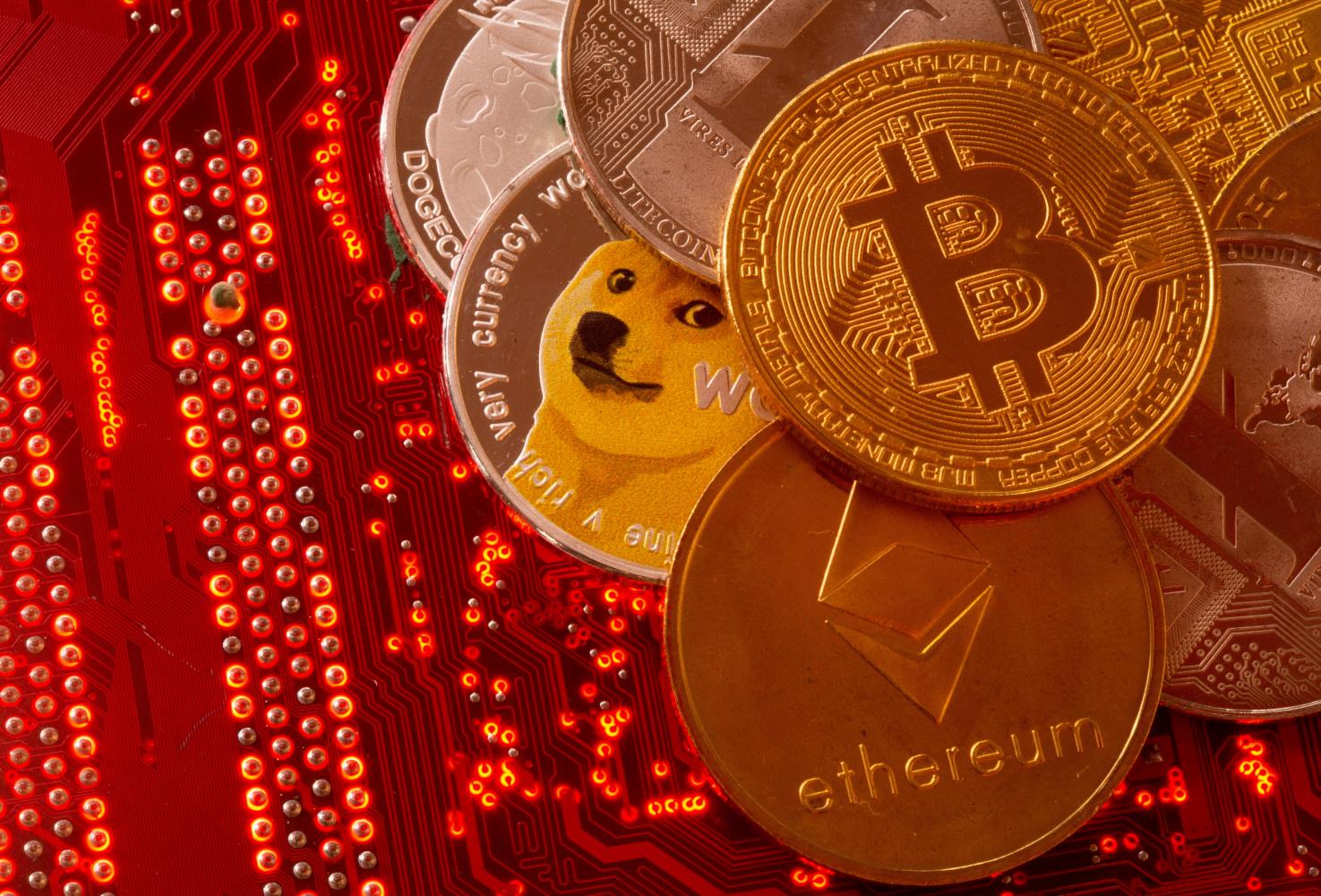 Representations of cryptocurrencies Bitcoin, Ethereum, DogeCoin, Ripple and Litecoin are displayed on a PC motherboard in this illustration. (Reuters photo)