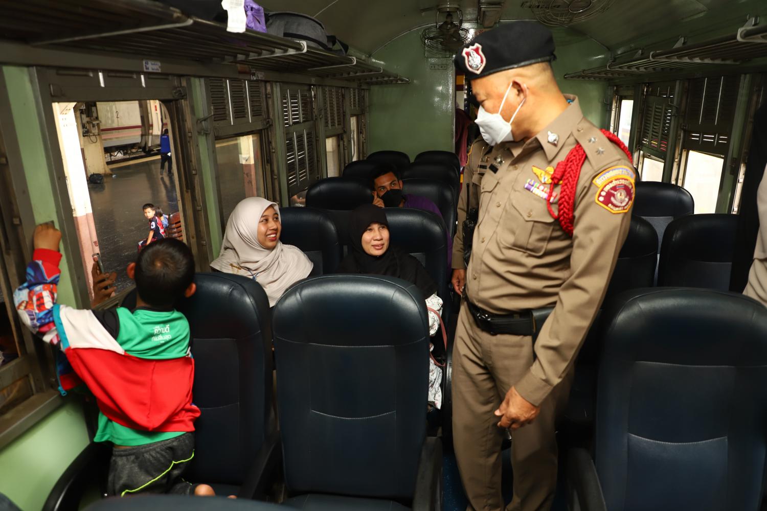 A police officer talks to passengers on a train leaving Hua Lamphong station. The Railway Police Division will be disbanded next year, drawing to a close its 128-year history. (Photo: Nutthawat Wicheanbut)