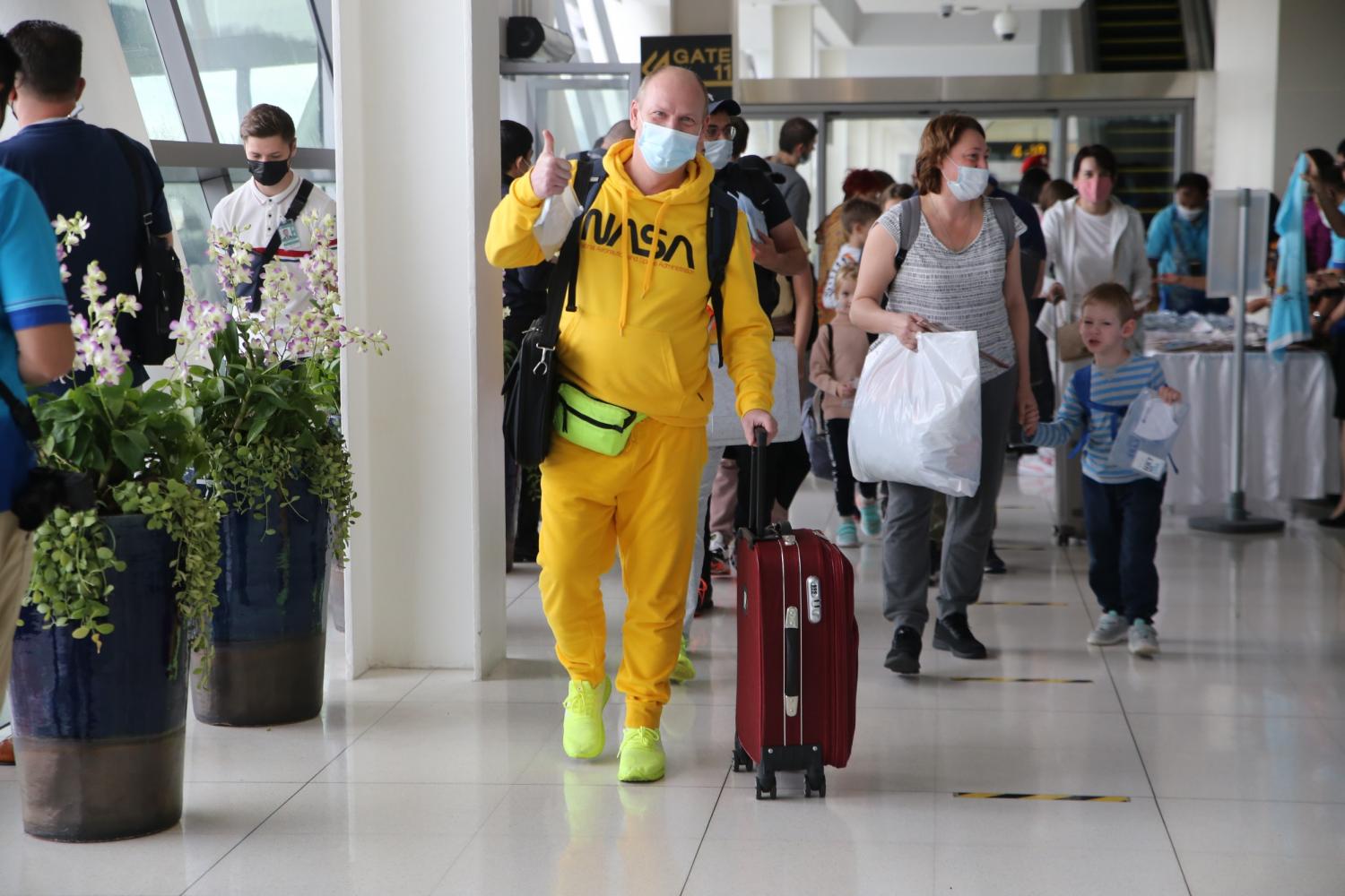 Russian tourists walk through the airport upon arrival in Phuket. (Photo: Achadthaya Chuenniran)