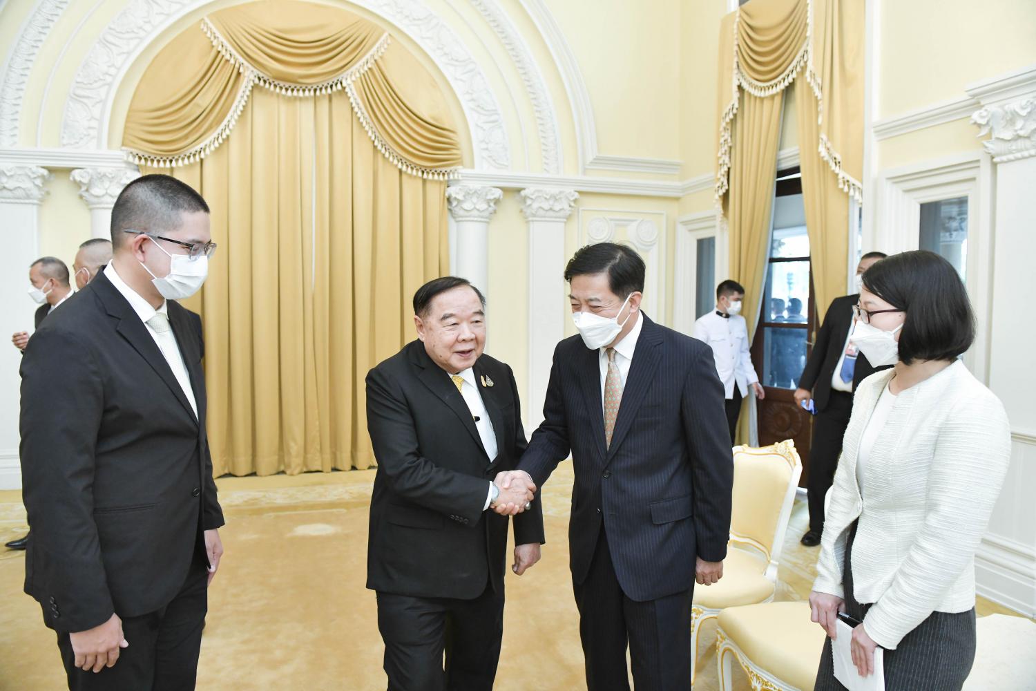 Deputy Prime Minister Prawit Wongsuwon shakes hands with Chinese ambassador Han Zhiqiang while welcoming him to Government House yesterday. GOVERNMENT HOUSE