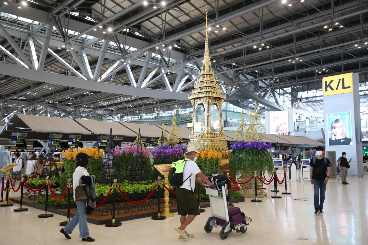 Travellers walk with their luggage at Suvarnabhumi airport. Varuth Hirunyatheb