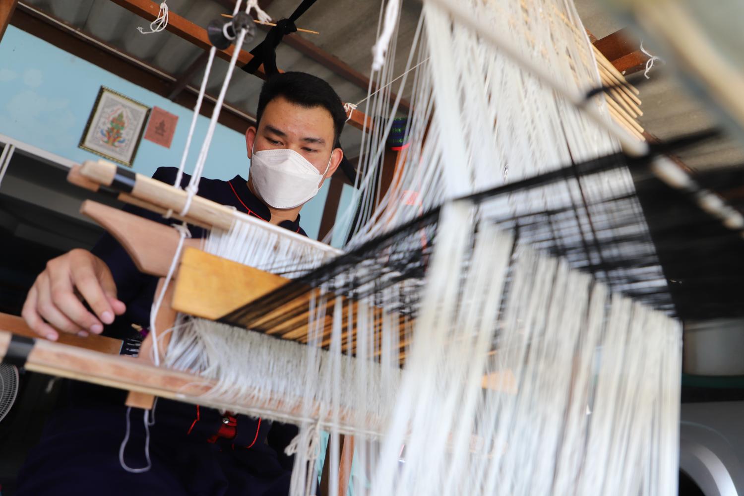 Teaching Textiles: Warut Manprom, founder of Wong Duean Jok Tai-Yuan Group in Nakhon Pathom's Kamphaeng Saen district, demonstrates how to weave Tai-Yuan textiles.