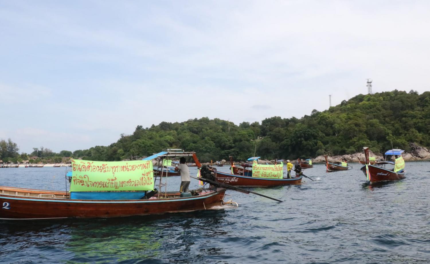 Sea gypsies travel in their boats along the shore of Koh Lipe on Dec 15. They have urged the government to solve a land dispute after a private firm closed off access from their village to the sea, a school, a hospital and a graveyard.  (Photo: Satun Public Relations Office)