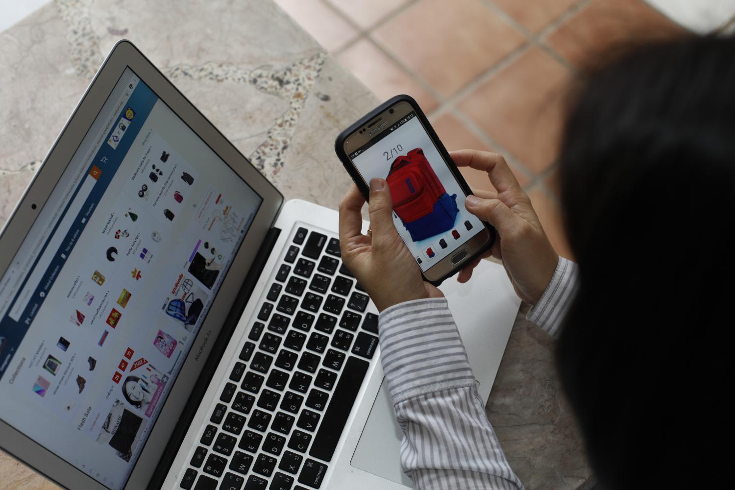 A shopper browses products on Lazada's website. VARUTH HIRUNYATHEB