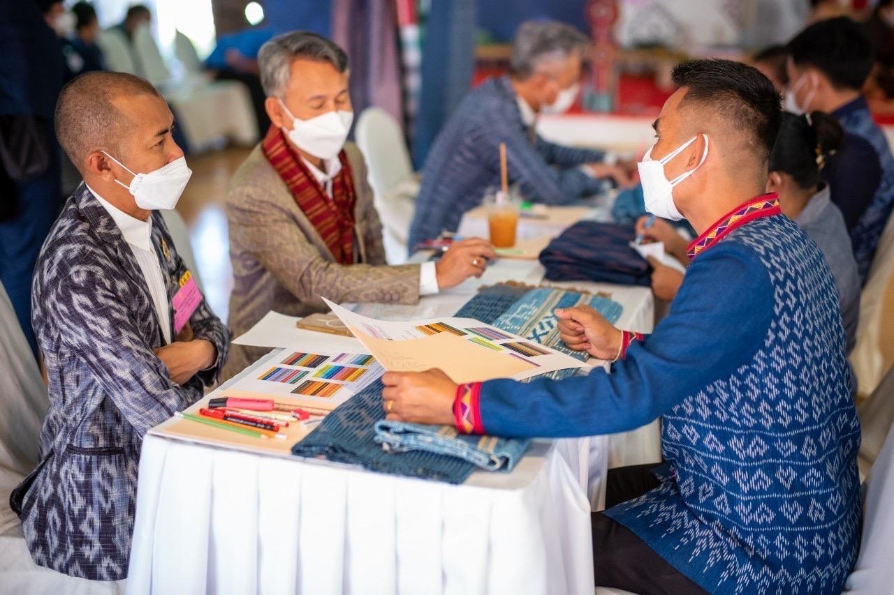 A team of designers meet weavers from 22 Otop groups in Sakon Nakhon's Khok Sri Suphan district to give advice on improving their products. (Interior Ministry photo)