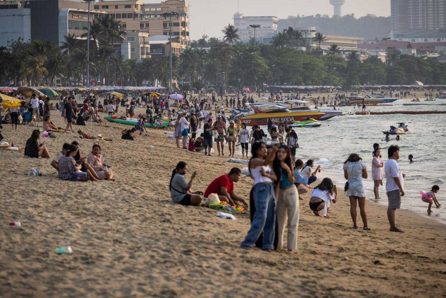 Locals enjoy some free time on a beach in Pattaya on Sunday as the revival of the country's vital tourism sector continues. (Photo: Bloomberg)