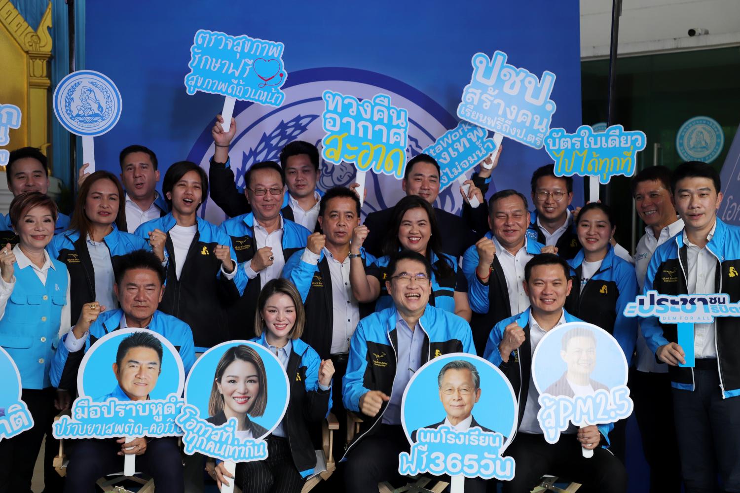 Prominent members of the Democrat Party hold up placards showing the party's policies. The party is organising a 'Policy Exhibition' to showcase its campaign pledges at its head office in Bangkok. (Photo: Chanat Katanyu)