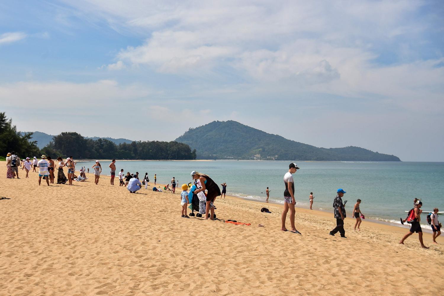 Tourists enjoy Mai Khao beach in Phuket on Feb 13, 2023. An influx of foreigners has propelled the real estate market on the island.