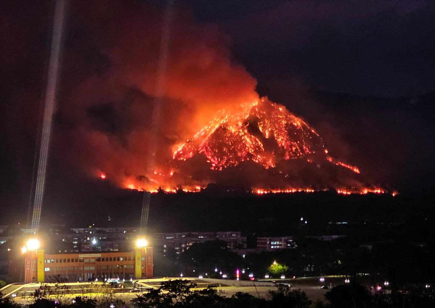 The slopes of Khao Chaphlu in Nakhon Nayok are engulfed in flames on Wednesday evening. The fire, believed to be caused by lightning, has destroyed at least 700 rai of forest across three mountains. Facebook: Thee Nee Nakhon Nayok