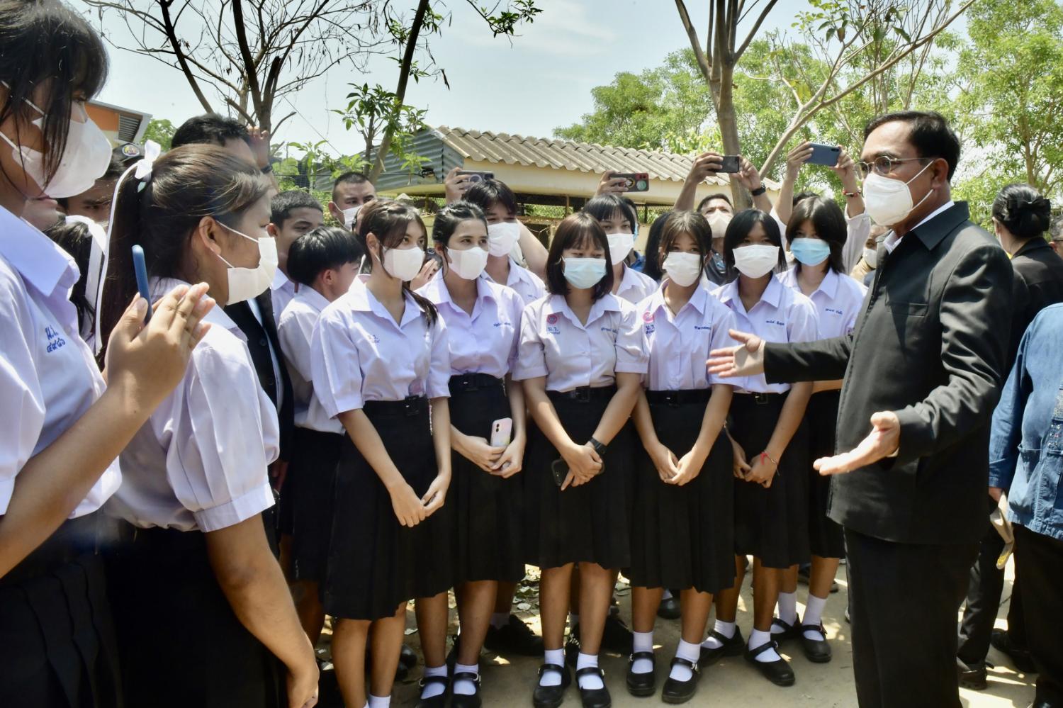 Prime Minister Prayut Chon-o-cha chats with students at Ban Noen Po School and locals in Sam Ngam district. GOVERNMENT HOUSE photo