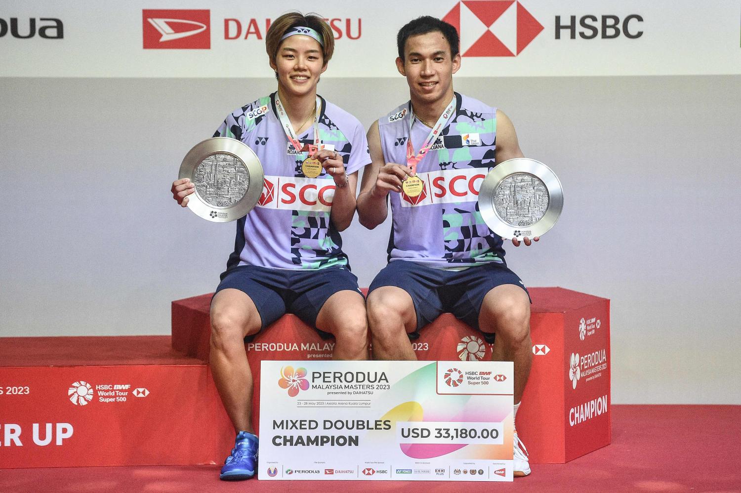 Sapsiree Taerattanachai, left, and Dechapol Puavaranukroh pose with their trophies and gold medals after winning the mixed doubles title. (AFP photo)