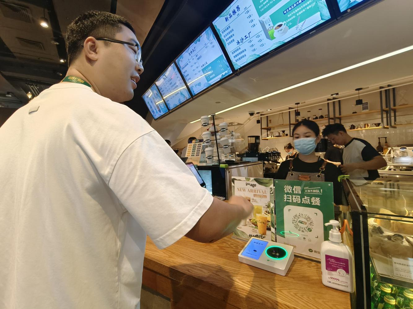 Using technology utilised by Tencent's Weixin Pay, a customer's palm is scanned as part of the payment process at a coffee house.