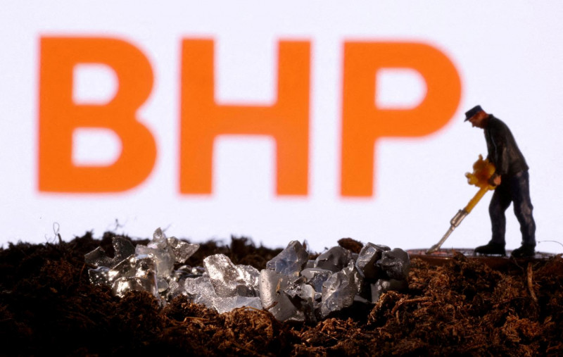 A small toy figure and mineral imitation in front of the BHP logo in this illustration photo taken in November 2021. REUTERS