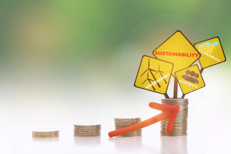 Yellow signs reading 'environment, sustainability, society, and economics' are seen atop a stack of coins representing shifting concepts related to sustainability and investment. (Photo: 123RF.com)