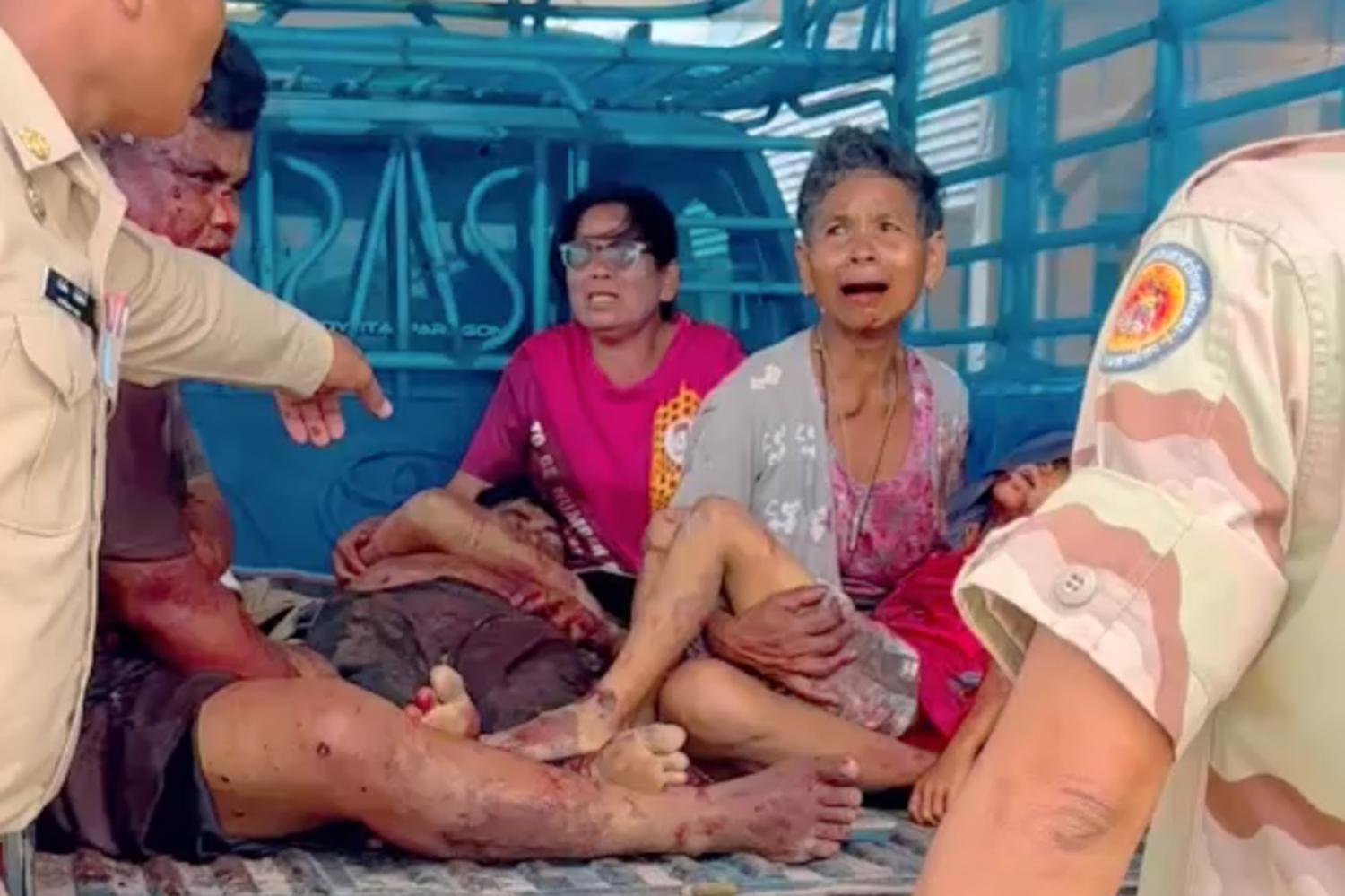 A grandmother weeps while carrying her 8-year-old grandson to hospital after Cambodia fired a rocket into their home in Kap Choeng district, Surin, killing two family members including the boy and injuring two others. ARMY MILITARY FORCE FACEBOOK