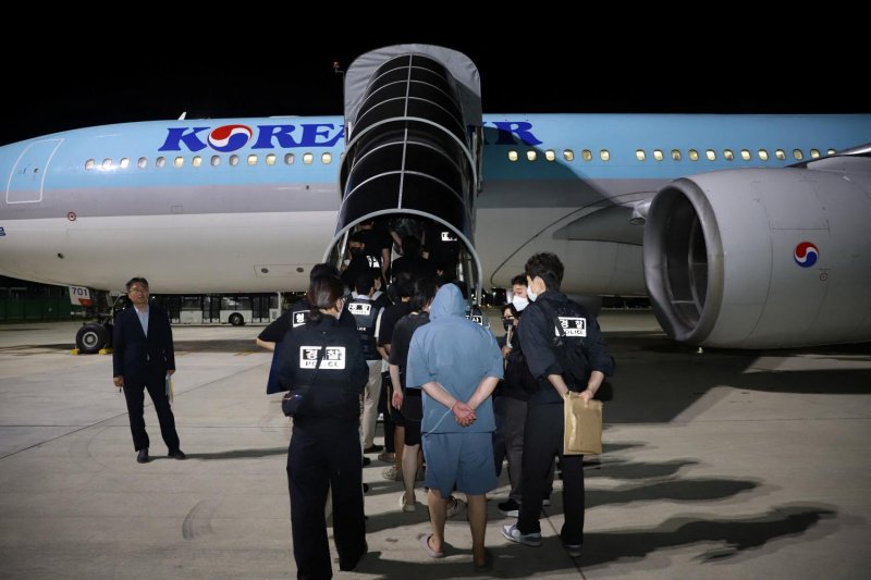 South Korean police officers return South Korean nationals suspected of being involved in online scam operations. (Photo: Reuters)