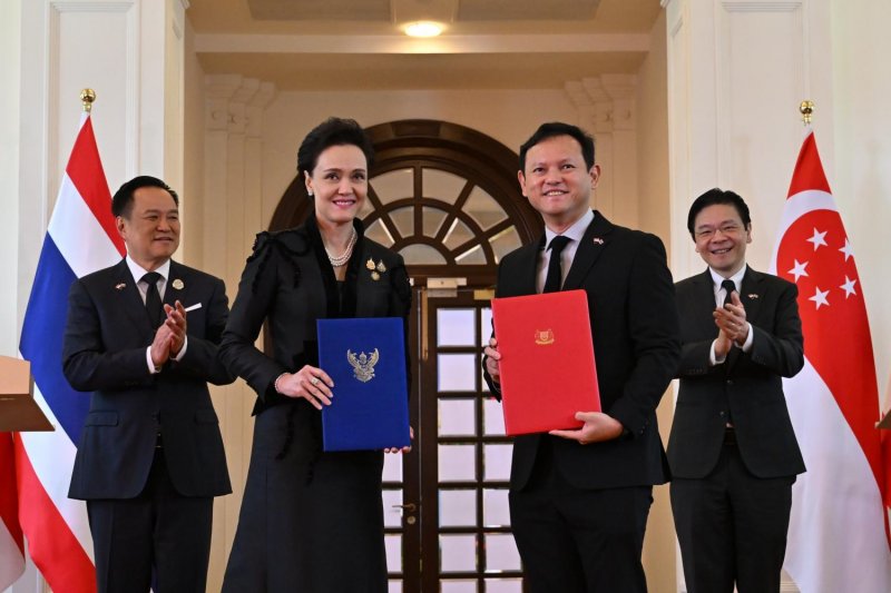 Thai Prime Minister Anutin Charnvirakul, left, and Singaporean Prime Minister Lawrence Wong, right, witness the signing of a rice trade memorandum by Thai Commerce Minister Suphajee Suthumpun, second left, and Senior Minister of State for Defence and Manpower Zaqy Mohamad, second right. (Photo: Government House)