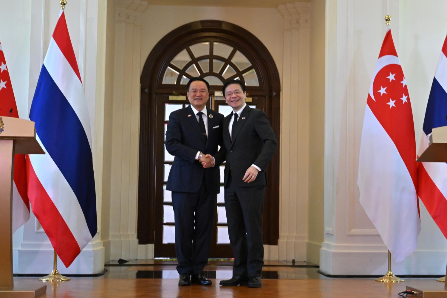 Prime Minister Anutin Charnvirakul shakes hands with Singaporean Prime Minister Lawrence Wong during his official visit to Singapore yesterday, marking 60 years of diplomatic relations. PHOTOS: GOVERNMENT HOUSE
