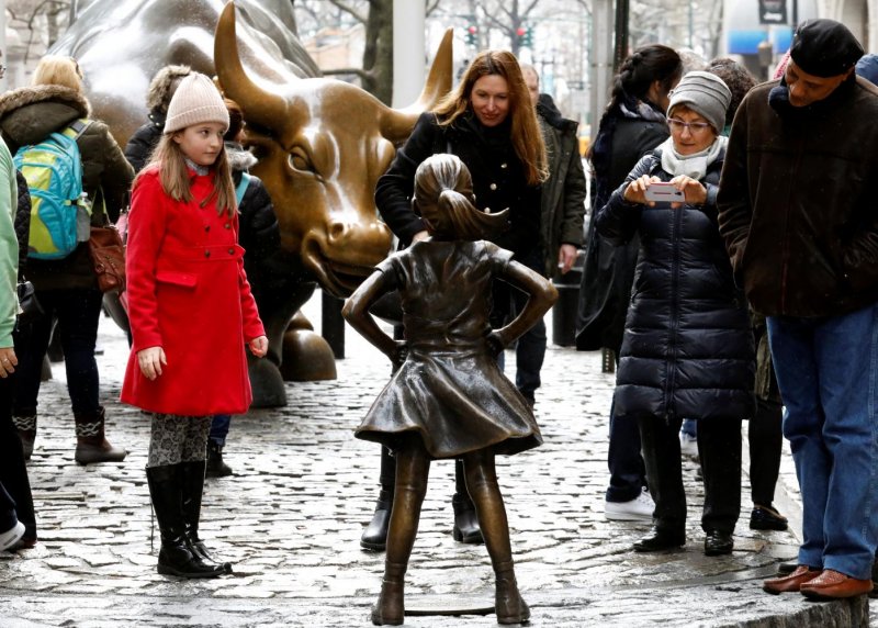 This photo, dated March 7, 2017, shows people looking at a statue of a girl facing the Wall Street Bull in New York. (Photo: Reuters)