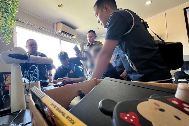 Central Investigation Bureau (CIB) police raid a Chon Buri apartment on March 11, arresting a 54-year-old foreigner (middle, in blurred face), who was allegedly selling sexually explicit images of children on the dark web. (Photo courtesy of CIB)