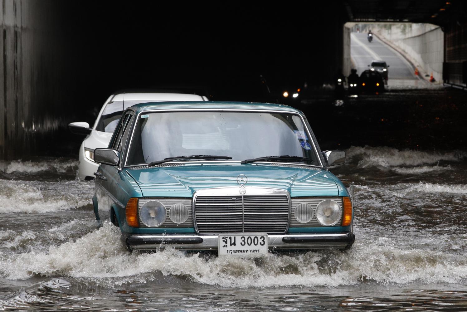 Cars trudge through a flooded underpass on Liab Tang Rotfai Road, Bang Sue district, Bangkok following heavy rains in early November. Flooding in the capital following monsoon rains was compared with the linked nature of trade talks with the US and the border pact with Cambodia. Pattarapong Chatpattarasill