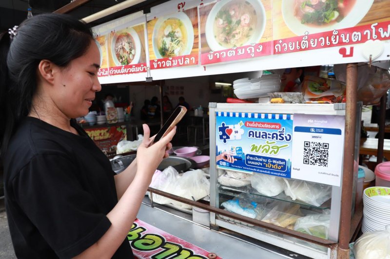 ผู้บริโภคสแกนโค้ด QR เพื่อซื้ออาหาร นายนันทพงศ์กล่าวว่าโครงการชำระเงินร่วมช่วยยกระดับความเชื่อมั่นของผู้บริโภค และการริเริ่มลดค่าครองชีพในระยะยาวอาจช่วยเพิ่มอุปสงค์ของครัวเรือนและส่งผลต่ออัตราเงินเฟ้อ (ภาพ: สมชาย ภูมิหลาด)