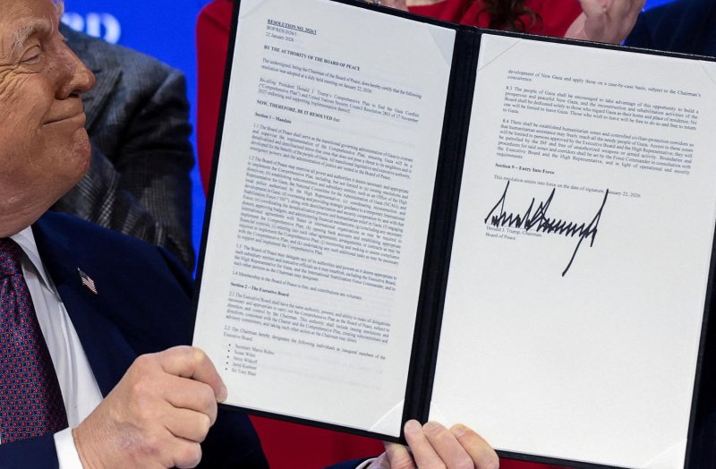 US President Donald Trump holds a signed resolution on Jan 22 as he attends a charter announcement for his Board of Peace initiative aimed at resolving global conflicts, in Davos, Switzerland. (Photo: Reuters)