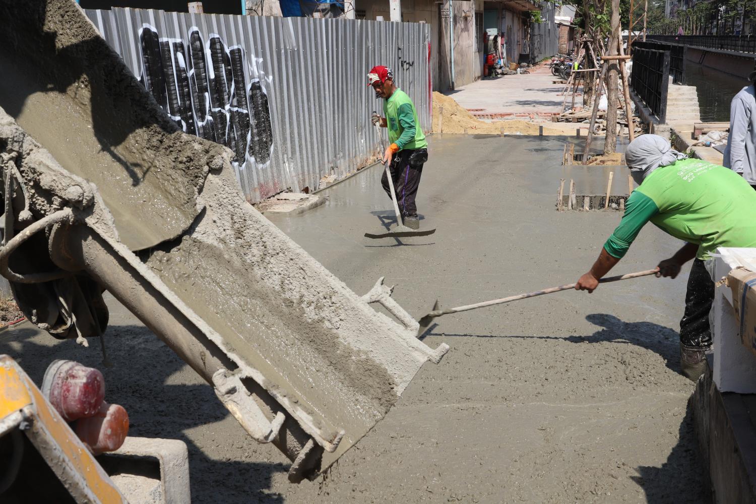 Workers smooth cement at a Bangkok construction site. Cement is one of the first three sectors to be regulated by CBAM. Apichart Jinakul