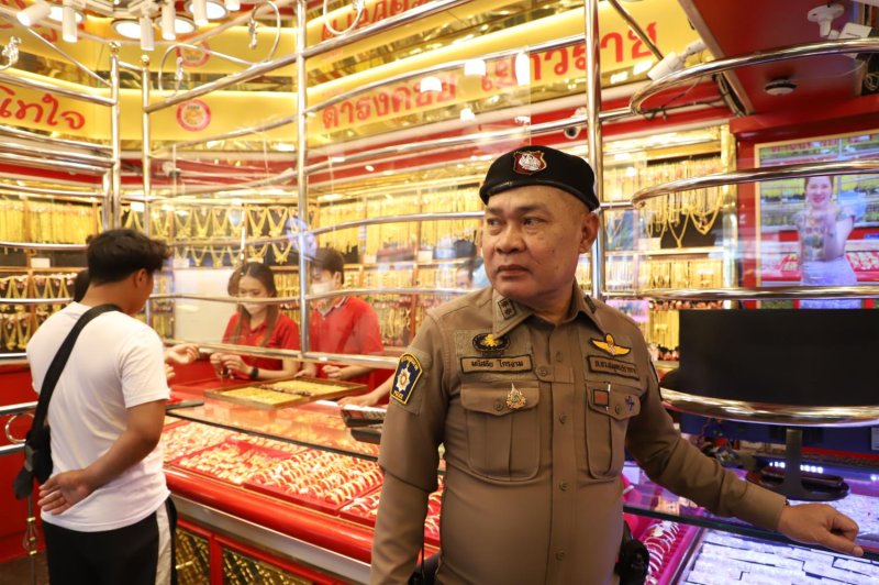 An officer from Samrong Nuea police station in Samut Prakan patrols a local gold shop to prevent robberies, keeping an eye on suspicious customers and advising shop owners to install alarms and limit gold displays. (Photo: Somchai Poomlard)
