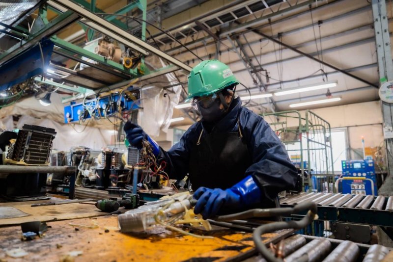 Above  An employee of Eco-Recycle dismantles an electronic device into individual components.