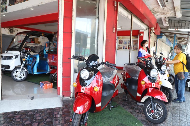 A consumer explores electric scooters and motorcycles on sale at a Samut Prakan outlet, looking for an affordable alternative amid rising fuel costs.