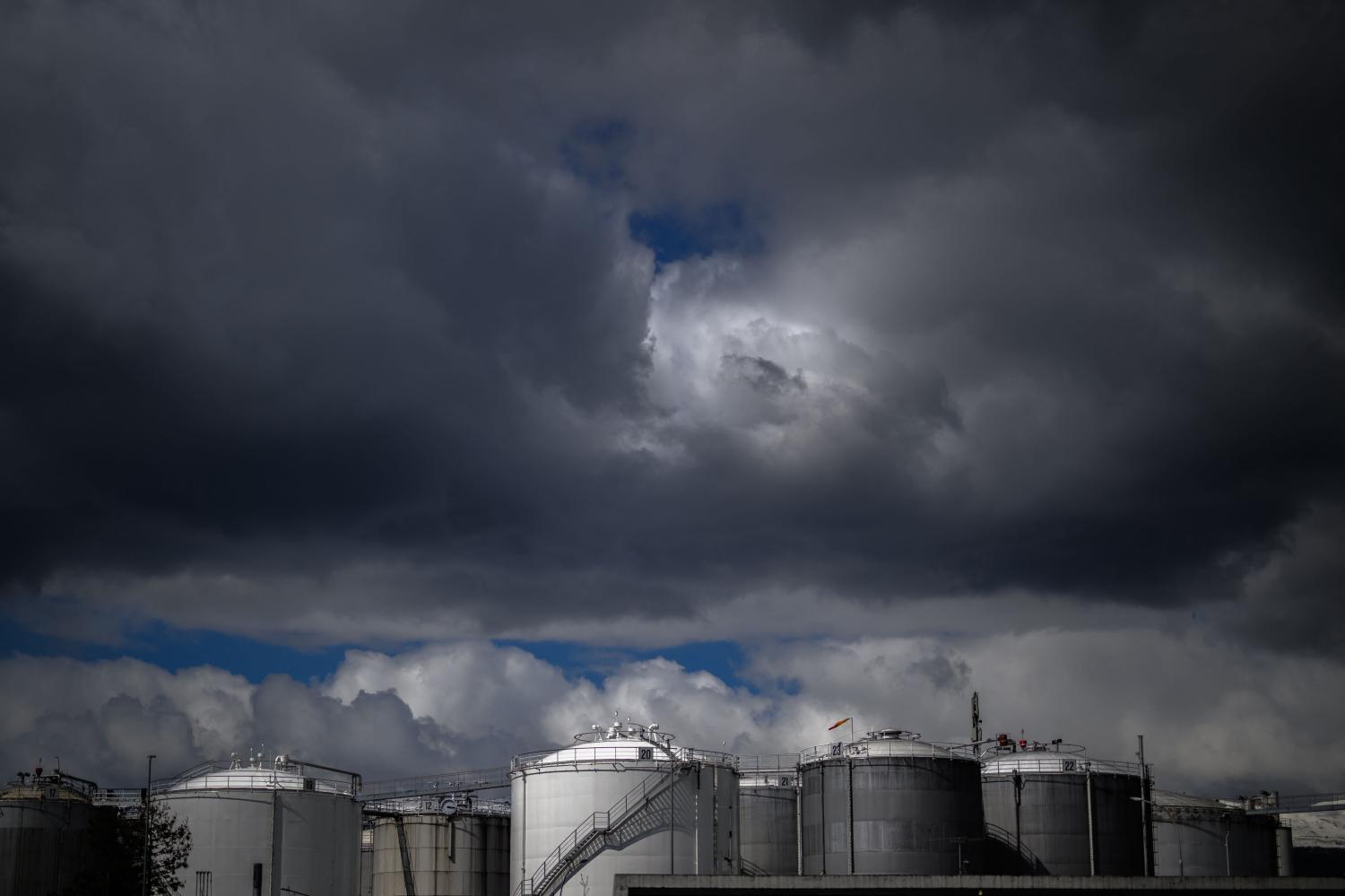 Gasoline and fuel storage tanks under heavy clouds in Vernier, near Geneva. The US-Israeli war with Iran has spread across the Gulf and beyond, disrupting global energy markets and trade.&thinsp;AFP