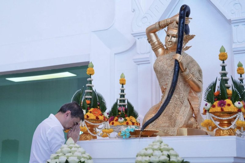 Democrat leader Abhisit Vejjajiva performs a ritual offering to the Phra Mae Thorani statue at the Democrat headquarters to mark the party's 80th anniversary. (Photo courtesy of Democrat Party)