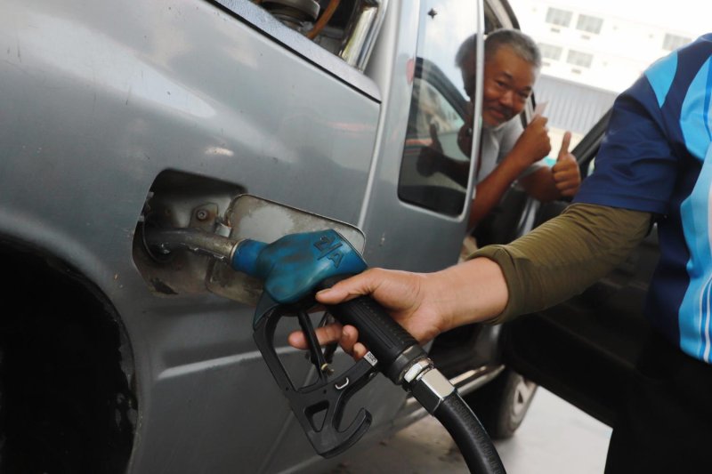 A motorist gives a thumbs-up while his vehicle is refuelled, as higher oil prices discourage pickup purchases. (Photo: Somchai Poomlard)
