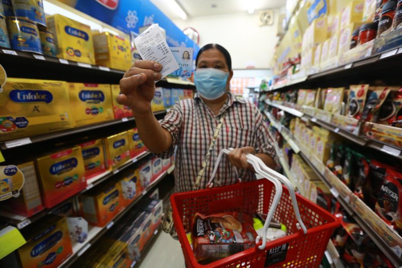 People buy food with the state welfare card at a supermarket. The Prayut government distributed welfare cards to roughly 14 million people, but the national planning agency estimated only 4.8 million poor people in Thailand. Somchai Poomlard