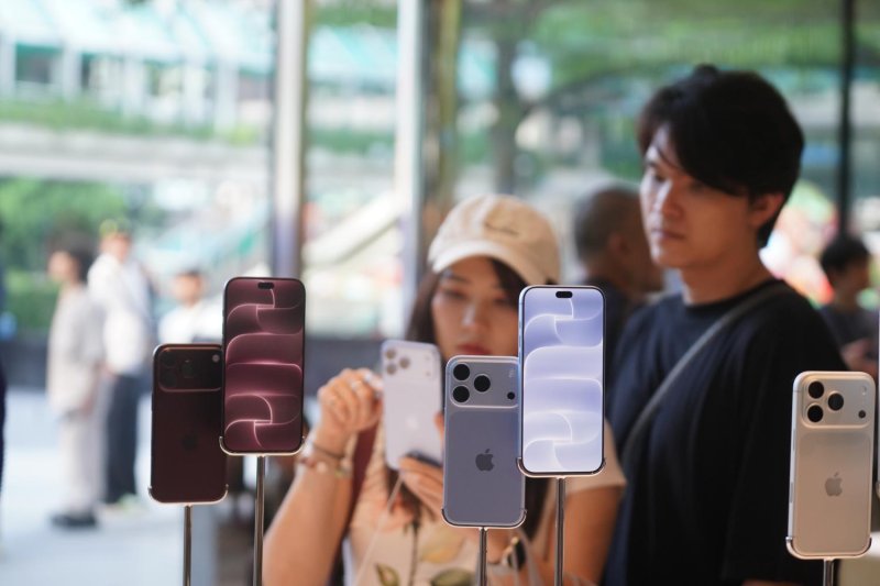 Consumers at the Apple Store in CentralWorld mall try out an iPhone 18 on the first day of sales in Thailand.