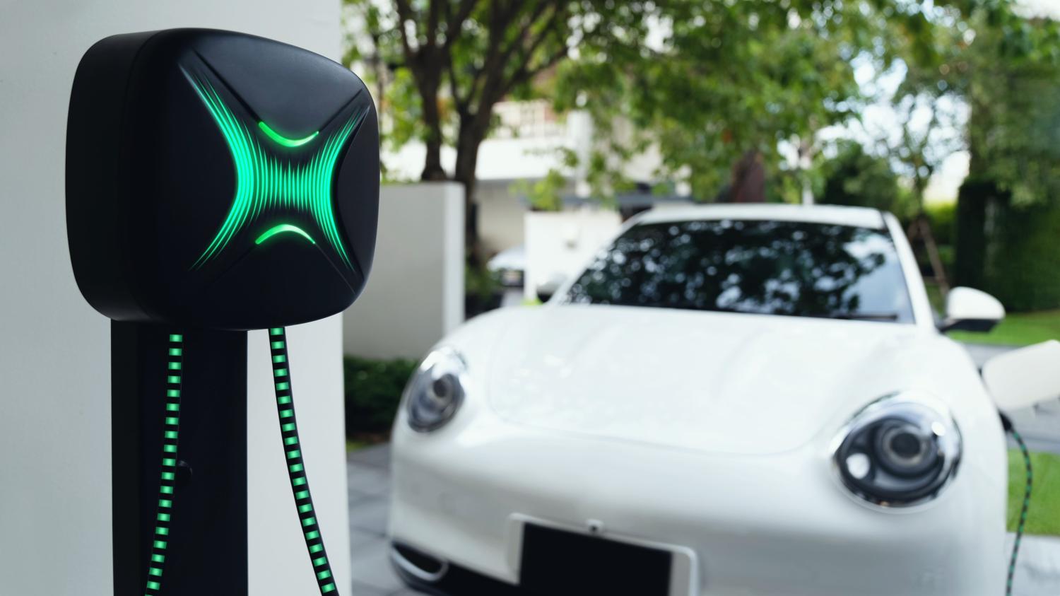 An electric vehicle is plugged into a home charging station.