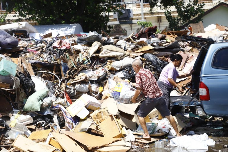 Flood-damaged belongings are piled up at a temporary waste collection site in a car park in Bangkok's Bang Kapi district. Severe flooding late last month caused widespread damage to homes and businesses. Nutthawat Wichieanbut
