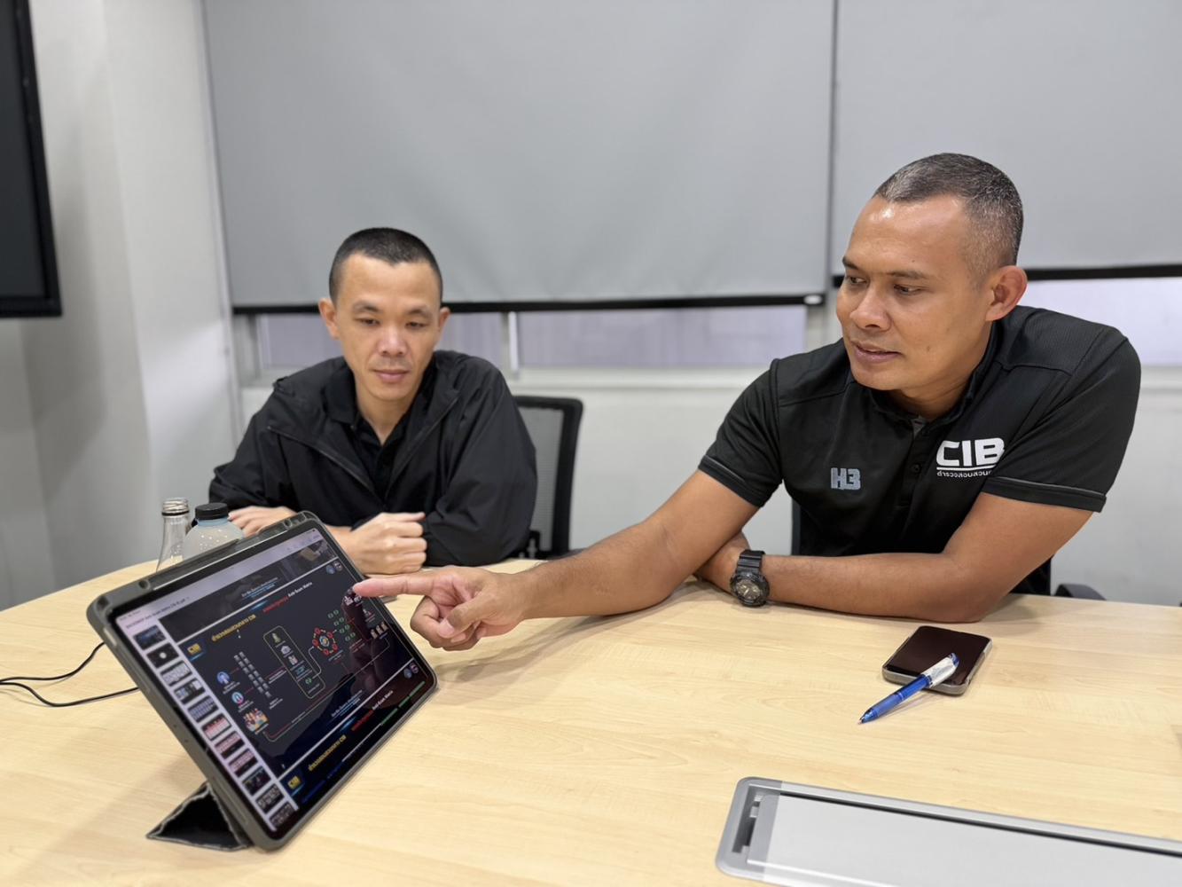 Pol Col Tanawat Hinyokhin, superintendent of Sub-Division 5, right, and Pol Lt Col Sarun Sripuk, deputy superintendent of Sub-Division 5, left, show how police traced cryptocurrency transactions. Wassayos Ngamkham
