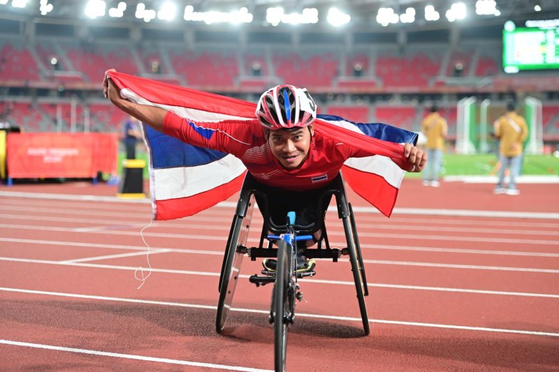 Wheelchair racer Pongsakorn Paeyo celebrates with the Thai flag. Supplied photo