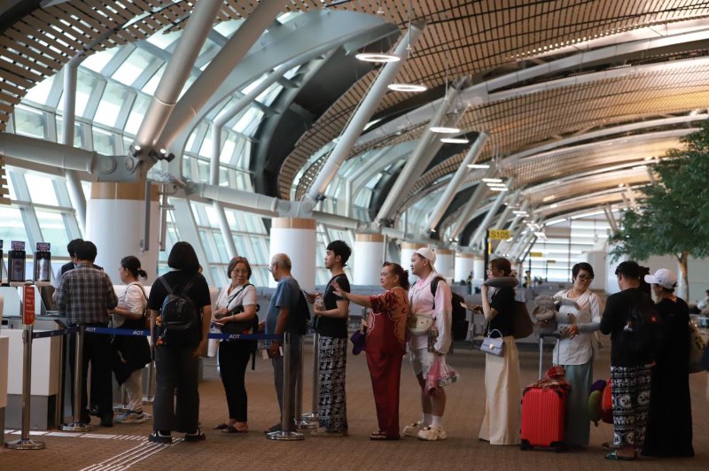 Tourists queue up to board a flight at Suvarnabhumi airport. The Finance Ministry is pushing a levy on all outbound passengers to bolster government revenue.
