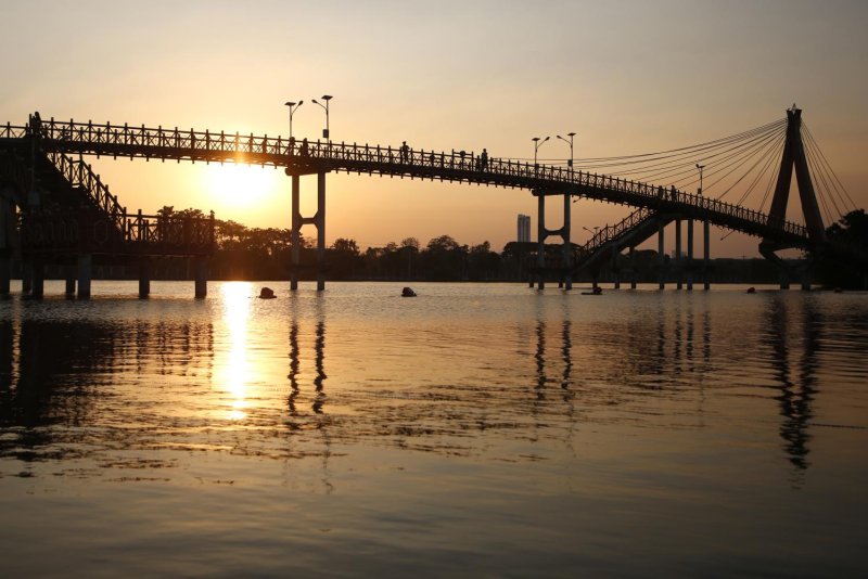 People enjoy the sunset over the Bueng Nong Bon, a 'monkey cheek' reservoir project in Prawet district initiated by the late King Rama IX to manage water in the eastern part of Bangkok. Bueng Nong Bon has an area of more than 644 rai and can support more than 5 million cubic meters of water. Bangkok Post file photo